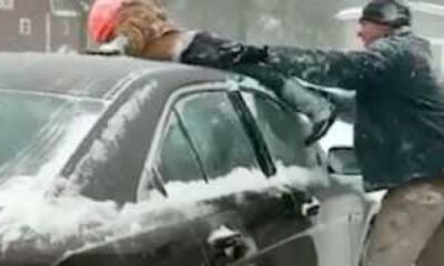 Bir baba, arabasının üzerindeki karları temizlemek için çocuğunu kullandı